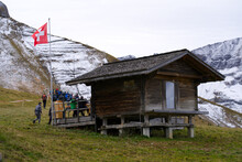 Wooden Chalet With Swiss Flag Blowing In The Wind At Mountain Station Of Chair Lift At Axalp, Canton Bern, On A Grey And Cloudy Autumn Day. Photo Taken October 19th, 2021, Brienz, Switzerland.