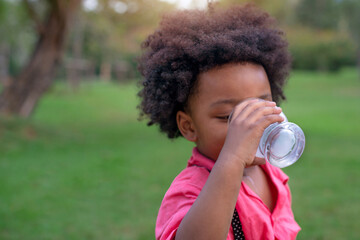 African American boy drinking milk at green park, selective focus