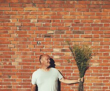 Man Standing Against Brick Wall