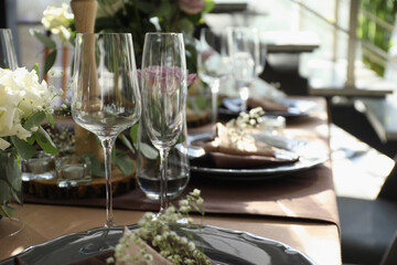 Festive table setting with beautiful tableware and floral decor in restaurant