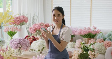 Wall Mural - Asia people young woman SME owner happy smile look at camera enjoy open flower shop sale order web page work at home office workspace. Loan money banking for social media commerce online store seller.