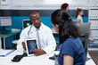 © DC Studio - African american pediatrician doctor holding tablet computer explaining radiography expertise to mother during clinical consultation in hospital office. Bones xray on screen. Health care service