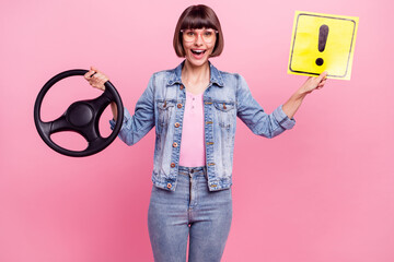 Wall Mural - Portrait of attractive cheerful girl holding in hands steering wheel exclamation point isolated over pink pastel color background