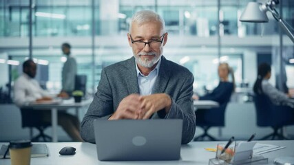 Poster - Modern Office: Portrait of Successful Middle Aged Bearded Businessman Working on a Laptop at his Desk. Smiling Corporate Worker. Multi-Ethnic Workplace with Happy Professionals. Front View Static Shot
