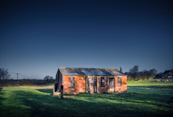 Wall Mural - Old barn in moonlight with starry night sky, UK