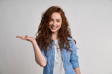 Smiling adult woman showing at empty copy space