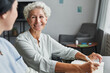 © Seventyfour - Portrait of smiling senior woman talking to female caregiver at home, copy space