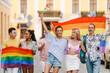 © Drobot Dean - Multiracial men and women walking with rainbow flags during pride parade