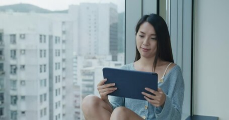 Canvas Print - Woman read on tablet and sit beside window