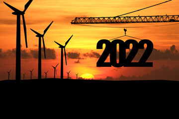 Concept Happy new year Silhouette of construction to create lifting crane 2022 and wind turbine on sunrise background.