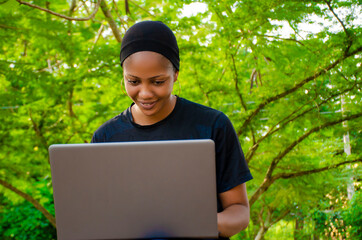 lady feeling excited as she is using her laptop outside