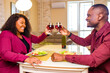© yurakrasil - Authentic people african american couple in love drinking wine from glasses and eating italian pasta in living room 14 february valentines day