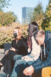 © Rytis - New is normal, Covid-19, social distance concept. Group of friends with protective face masks sitting and talking on bench during pandemic. Bright vivid backlight filter. Farthest woman is in focus