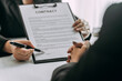 © sirichai - close up of business people or lawyers discussing and signing a contract or business agreement at law firm office, business people discuss document legal, law, and justice advice service concept.