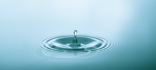 Wall Mural - splash of water droplets on a smooth water surface