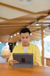 © Ranta Images - Young man at coffee shop using digital tablet computer