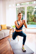 © gzorgz - Sporty woman training at home in the sitting room