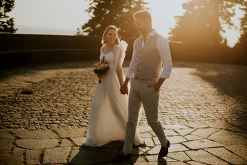 Wall Mural - Young newlywed couple walking in the park