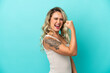 © luismolinero - Young Brazilian woman isolated on blue background celebrating a victory
