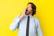 © luismolinero - Telemarketer dutch man working with a headset isolated on yellow background yawning and covering wide open mouth with hand