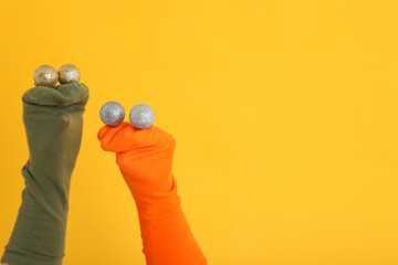 Wall Mural - Sock puppets with baubles on yellow background