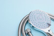 © iama_sing - Shower head chrome coated multi-mode for the bathroom with hose on blue background.
