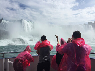 visitors to the canadian side of niagara falls wear masks while enjoying a river boat ride.