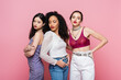 © LIGHTFIELD STUDIOS - Young multiethnic women posing during party isolated on pink