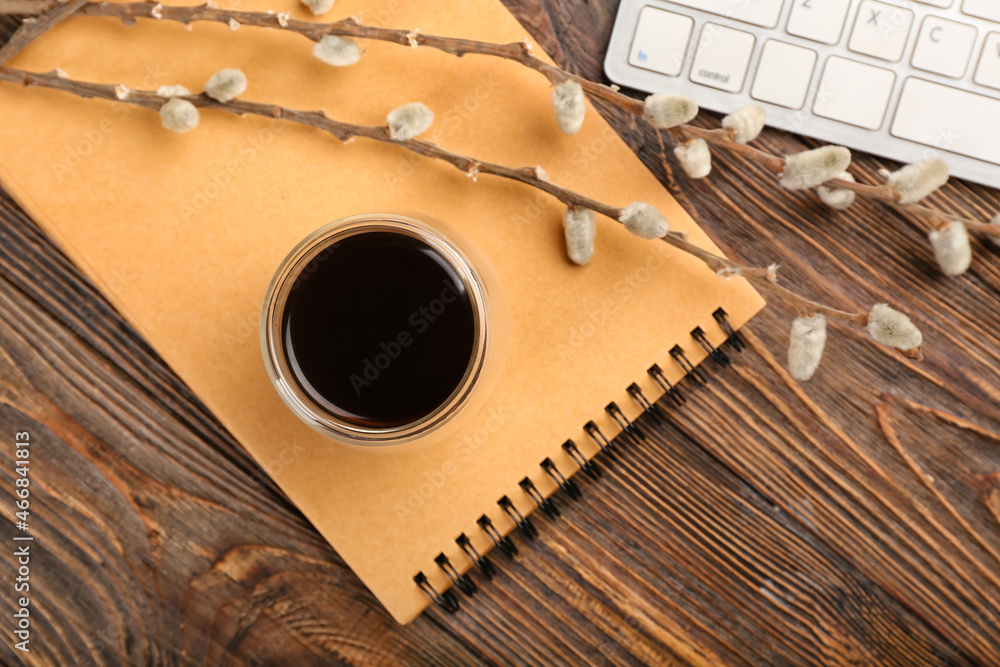Composition with cup of coffee and notebook on wooden background