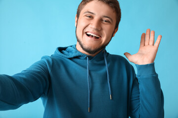 Sticker - Stylish young man taking selfie on color background