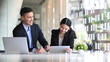 © Prathankarnpap - Two happy business colleagues discussing project planning in modern workplace.