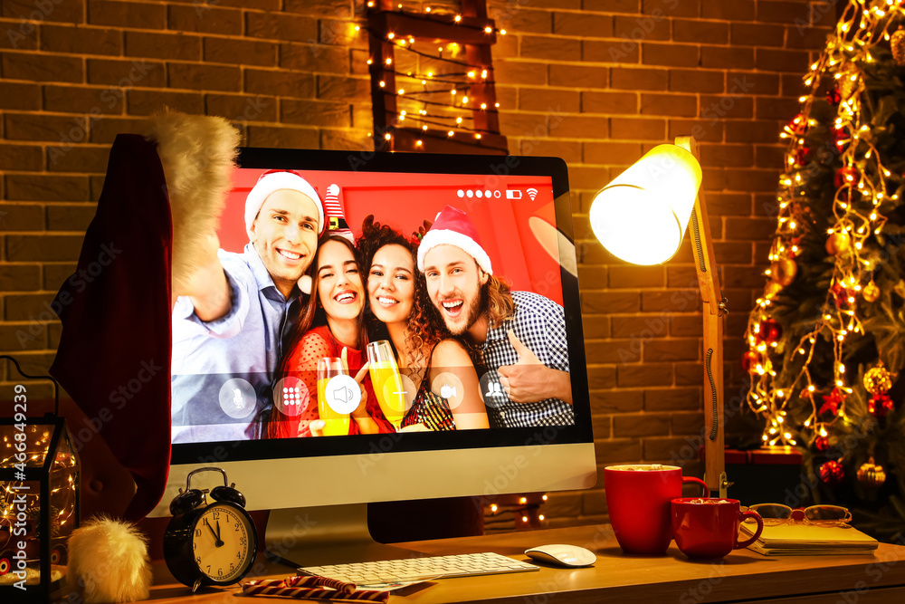 Computer on table in dark room. Celebrating Christmas online due to coronavirus epidemic