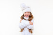 © Юлия Дьякова - a beautiful little girl in a warm sweater and a winter hat is smiling. Warm children's clothing.