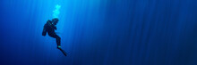 Background Banner With A Scuba Diver Woman Standing Still In Deep Blue With Sun Rays