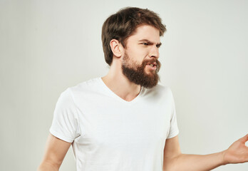 Canvas Print - emotional man in a white t-shirt hand gestures anger close-up