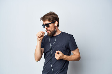 Wall Mural - handsome man in a black t-shirt music in headphones movement light background