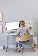 Young woman working on computer at table in room