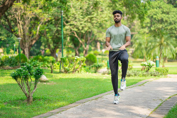 Indian man running on the spot in the park, warming up