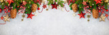 Fototapeta Na ścianę - Christmas or New Year banner with green fir branches, red berries, Christmas ornaments and cones. Winter holiday concept, top view, copy space