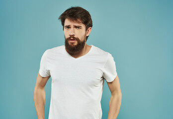 Canvas Print - bearded man in white t-shirt emotions displeasure upset blue background