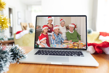 Poster - Smiling multi generation caucasian family in santa hats on laptop christmas video call screen