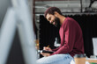 © LIGHTFIELD STUDIOS - Side view of smiling african american businessman writing on notebook near blurred coffee to go in office