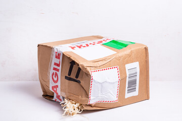 Broken cardboard box, fragille marked parcel