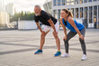 © Kostiantyn - Sportive middle aged couple, man and woman looking away, taking a short break while jogging together in the city on a warm summer day