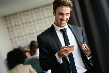 Poster - Young businessman sending message with mobile phone