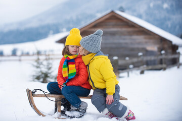 Wall Mural - Kids kiss. Cute children boy and girl kissed on a winter walk in nature. Winter knitted kids clothes. Cold weather. Happy little kids wearing knitted hat, scarf and sweater.