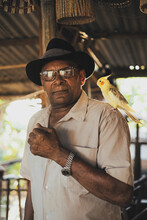 Stylish Black Man With Cockatiel Parrot On Shoulder Looking At Camera