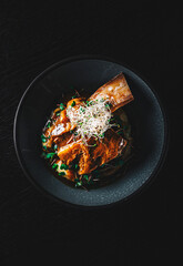 beef rib with mashed potatoes on plate on rustic wooden table dark background