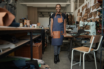 Young African female leather worker standing in her artisanal studio