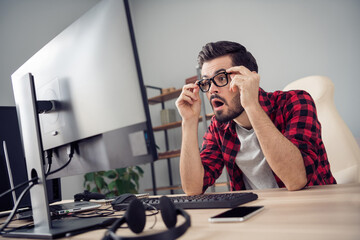 Portrait of attractive stunned focused guy reading browsing code security data operating system at office work place station indoor